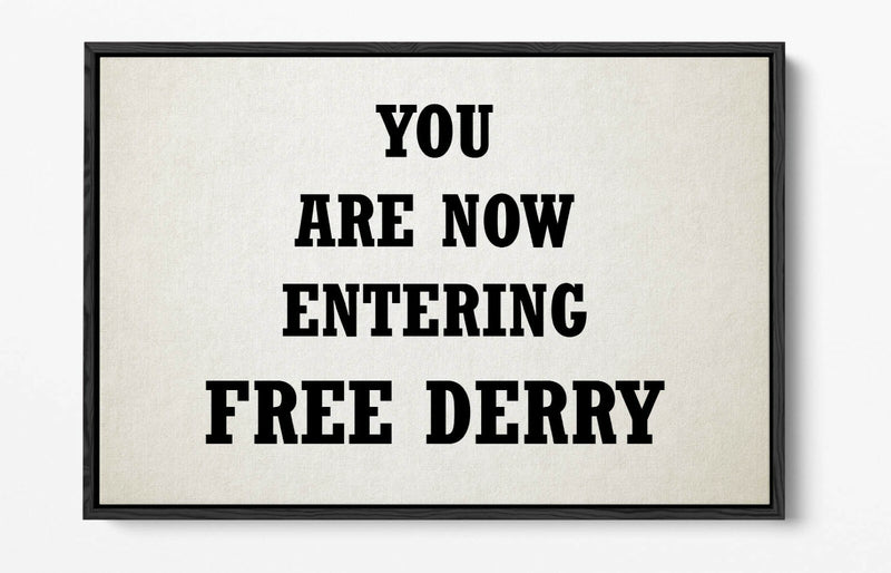 Framed sign with text 'YOU ARE NOW ENTERING FREE DERRY' on a plain background